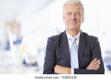 Portrait Of A Senior Financial Advisor Standing With Arms Crossed At The Office. 