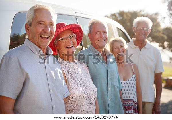Portrait Of Senior Friends Standing Together\
Beside Van On Vacation