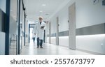Portrait of a Senior General Practitioner Using Tablet Computer to as He is Walking and Browsing Patient
