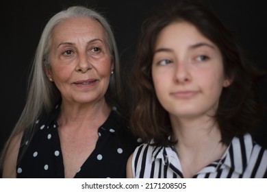 Portrait Of Senior Grandmother With Her Granddaughter Looking At Camera Over Black Blackground