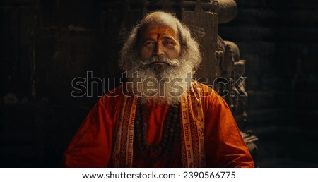 Portrait of a Senior Hindu Monk Looking at the Camera and Smiling While Wearing a scarf Written: 