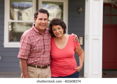 Portrait Of Senior Hispanic Couple Standing Outside House