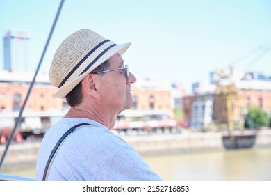 Portrait Of A Senior Hispanic Man Enjoying A Summer Day In Puerto Madero, A Trendy Neighborhood In Buenos Aires, Argentina. Concepts: Traveling And Enjoying The Outdoors, Active Retirement.