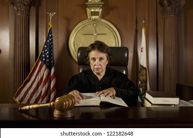 Portrait of senior judge holding book in courtroom - Powered by Shutterstock