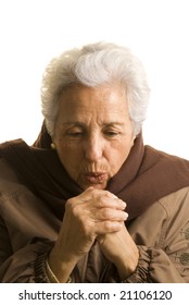 Portrait Of A Senior Lady In Winter Clothing Isolated On White, Trying To Keep Her Hands Warm.