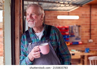 Portrait Of Senior Male Wearing Overalls In Garage Workshop With Hot Drink - Powered by Shutterstock