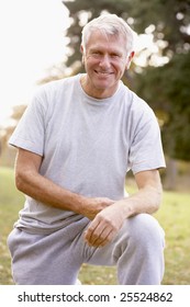 Portrait Of Senior Man Crouching In The Park