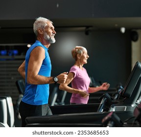 Portrait of a senior man exercising in a gym, mature couple running using treadmill machine equipment, healthy lifestyle and cardio exercise at fitness club concepts, vitality and active senior - Powered by Shutterstock