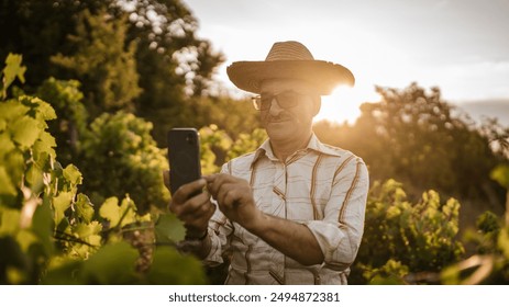 Portrait of senior man farmer stand in the vineyard use mobile phone - Powered by Shutterstock