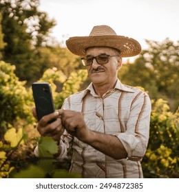 Portrait of senior man farmer stand in the vineyard use mobile phone - Powered by Shutterstock