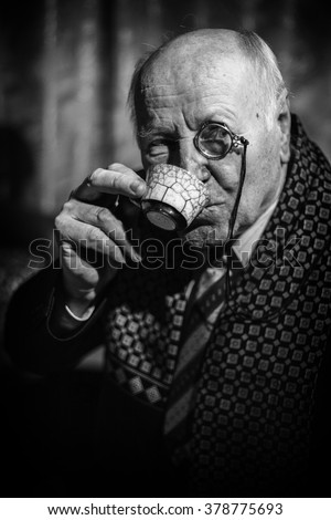 Portrait of Senior Man with monocle and a coffee cup