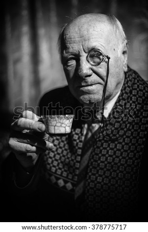 Portrait of Senior Man with monocle and a coffee cup