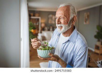 Portrait of senior man stand at home and eat salad - Powered by Shutterstock