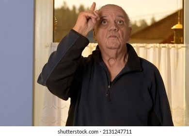 Portrait Senior Man Standing In Front Of Window Looking Up