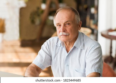 Portrait Senior Man Thinking And Looking At Camera At Home