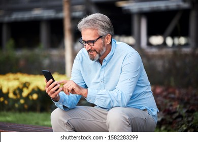 portrait of a senior man using a cell phone in the city  - Powered by Shutterstock