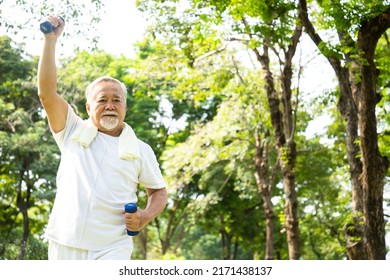 Portrait of a senior man using dumbbells at the park with good weather in the morning. Sport and Exercise concept. - Shutterstock ID 2171438137
