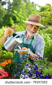 Portrait Of Senior Man Watering Flowers