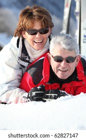 Portrait Of A Senior Man And A Senior Woman Laid In Snow