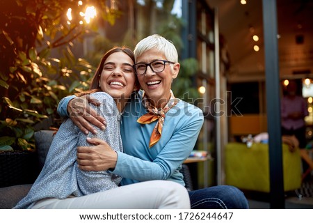 portrait of a senior mother and adult daughter, hugging, smiling. Love, affection concept