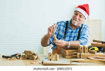 Portrait senior old aging kind Caucasian man or carpenter wearing santa hat, making DIY wooden furniture, holding eyeglasses, smiling with happiness, sitting alone at home. Retirement, Hobby Concept - Powered by Shutterstock