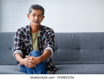 Portrait Of Senior Old Asian Man With Grey Hair And Beards Sitting Relax On Sofa With Happy And Calm Face.