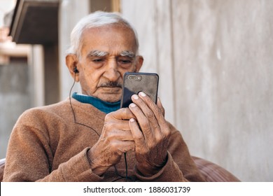 Portrait Of Senior Old Indian Man Watching Video On Mobile Phone. Modern Lifestyle Of Senior People. 