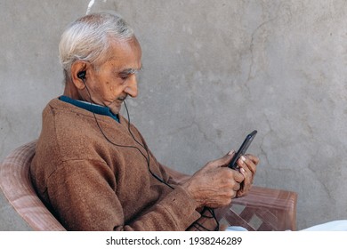 Portrait Of Senior Old Indian Man Watching Video On Mobile Phone. Modern Lifestyle Of Senior People. 