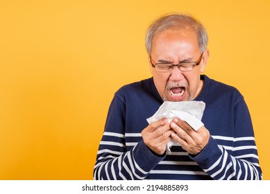 Portrait Senior Old Man Blowing Nose With Tissue Studio Shot Isolated On Yellow Background, Asian Elder Man Cold Having Flu And Sneezing From Sickness Virus Problem Use Tissue, Pensioner Unwell