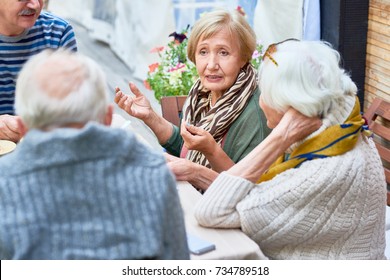 Portrait Of Senior People Enjoying Dinner Together, Focus On Lady Telling Stories To Friends Gesturing Actively