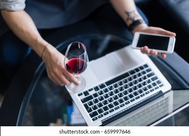 Portrait of senior sommelier sitting in front of laptop at wine cellar and tasting red wine while working together. Small business. - Powered by Shutterstock