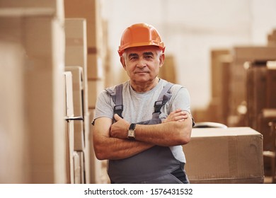 Portrait of senior storage worker in warehouse in uniform and hard hat. - Powered by Shutterstock