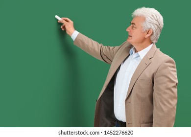 Portrait Of Senior Teacher With Chalk At Green Board, Space For Text