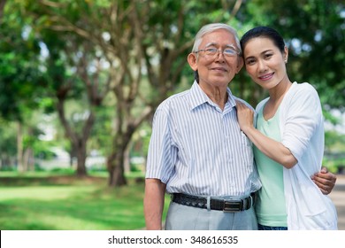 Portrait of senior Vietnamese man hugging his adult daughter