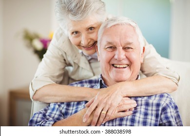 Portrait Of Senior Woman Embracing Man In Living Room