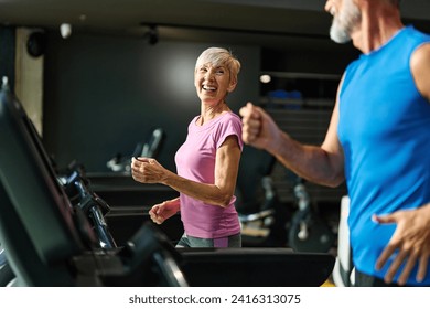 Portrait of a senior woman exercising in a gym, mature couple running using threadmill machine equipment, healthy lifestyle and cardio exercise at fitness club concepts, vitality and active senior - Powered by Shutterstock