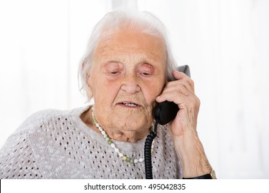 Portrait Of Senior Woman Having Conversation On Landline Phone