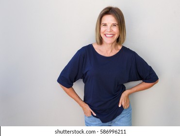 Portrait Of Senior Woman Laughing Against Gray Wall