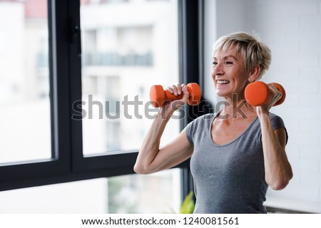 Portrait of senior woman lifting dumbbells