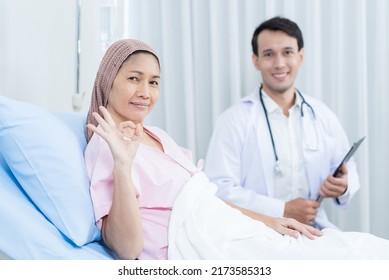 Portrait Of Senior Woman Patient Lying Down With Doctor In Hospital Ward. Physician Therapist Pharmacist Man Visit And Give Diagnosis Service Treatment Elderly Older Female And Smile, Look At Camera.