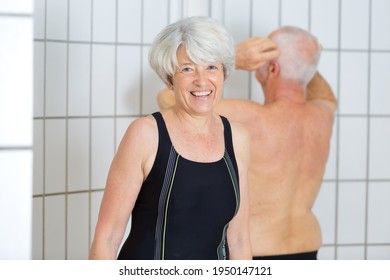 Portrait Of Senior Woman In Shower Area Of Swimming Pool