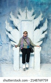 Portrait Of Senior Woman Sitting On Blue Throne