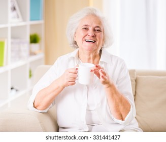 Portrait of senior woman sitting on the couch at home