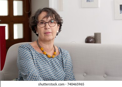 Portrait Of A Senior Woman Sitting On Her Sofa