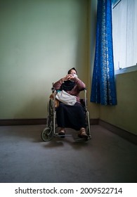 Portrait Of A Senior Woman Wearing Hijab On Wheelchair In A Hospital.