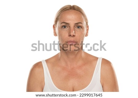 Portrait of a senior woman without make up Close up face of a mature blonde woman on a white studio background.