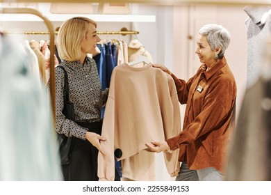 Portrait of senior woman working as sales assistant and helping customer at luxury boutique - Powered by Shutterstock