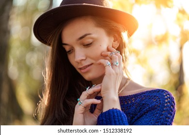 Portrait of sensual attractive boho chic woman in brown hat and knitted sweater wearing necklace and silver rings with turquoise stone. Stylish fashionable jewelry girl with boho fashion