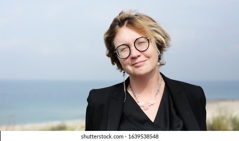 Portrait Of A Serious 40 Year Old Woman Walking Along The Beach