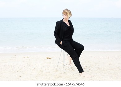 Portrait Of A Serious 40 Year Old Woman Walking Along The Beach